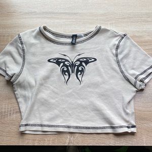 cream colored, cropped graphic T-shirt.